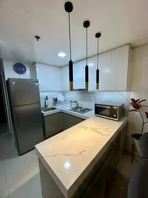 a kitchen with a refrigerator and a counter top at Kathys Crib 2Bedroom MOA View at Shell Residence in Manila