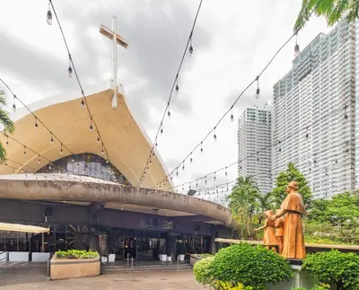 a church with a cross and a statue in front of it at Kintai Suites at the Beacon in Manila