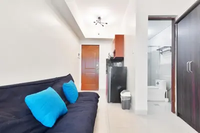a living room with blue pillows on a couch at Kintai Suites at the Beacon in Manila