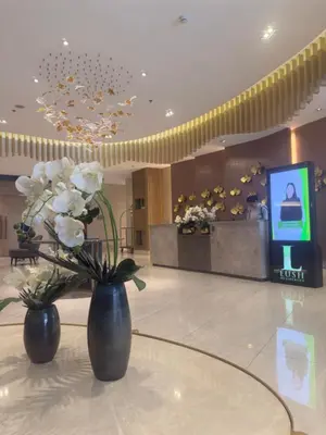 two vases with flowers on a table in a lobby at MAKATI - Lush Residences in Manila