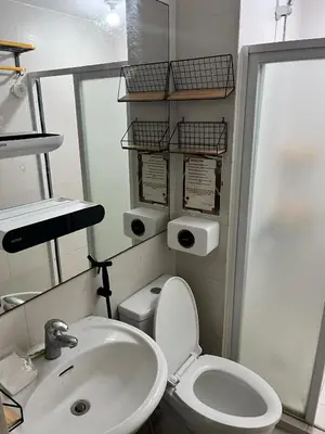 a bathroom with a white toilet and a sink at Serenity Escapes by Aj in Manila