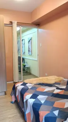 a bedroom with a bed in a room with a window at Joy Azure Escapes in Manila