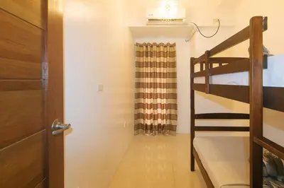 a room with a bunk bed and a door with a staircase at Stay Manila Hotel by RedDoorz in Manila