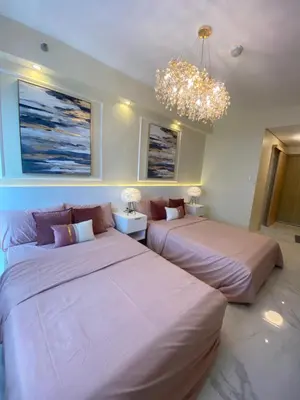 two beds in a room with a chandelier at Fairy Dust Sky Suite By Crib2GO in Manila