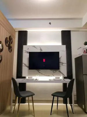 a room with a table with two chairs and a tv at Shore Residence Tower 3 in Manila