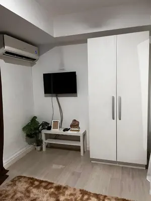 a living room with a tv and a white cabinet at Azure Condo Maui 1 bedroom in Manila