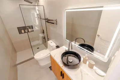 a bathroom with a sink and a toilet and a mirror at Éire Home Stay in Manila