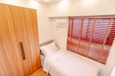 a small bedroom with a bed and a window at Éire Home Stay in Manila