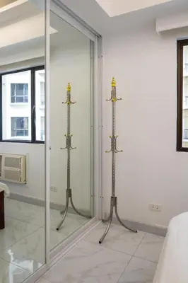 a mirror in a room with three metal towel racks at Forbeswood Heights BGC suite near st Lukes in Manila