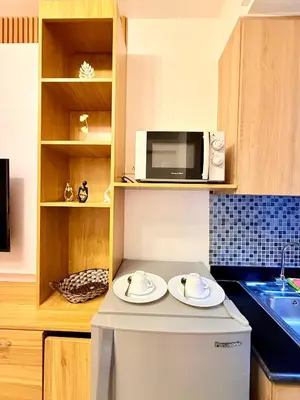 a kitchen with a microwave and two plates on a counter at Modern Double-Sized Bed with Netflix & Pool View in Manila