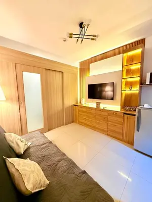 a living room with a bed and a television at Modern Double-Sized Bed with Netflix & Pool View in Manila