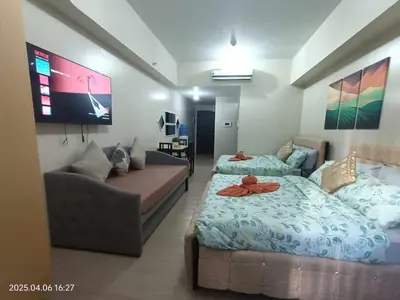 a living room with two beds and a couch at 81 Newport Boulevard across Manila Airport NAIA T3 in Manila