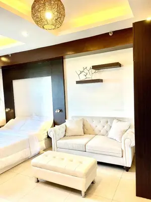 a living room with a couch and a bed at Cozy studio near Eastwood QC in Manila