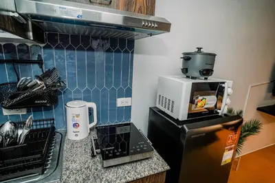 a kitchen with a coffee maker on top of a microwave at TahananStays at Makati CBD in Manila