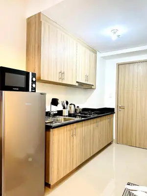 a kitchen with wooden cabinets and a stainless steel refrigerator at FT1161 House in Manila