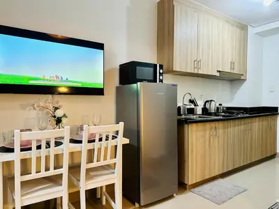 a kitchen with a refrigerator and a table and a tv at MK1661 House in Manila