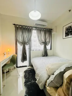 a bedroom with two beds and a desk and a window at TM1410 House in Manila