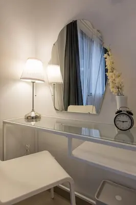 a glass table with a lamp and a mirror at SB1054 House in Manila