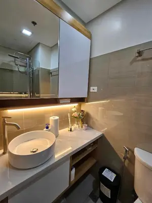 a bathroom with a sink and a mirror at Graceful Getaway Suites in Manila