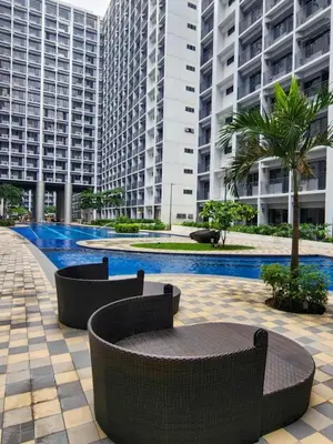 a courtyard with two chairs and a large building at Graceful Getaway Suites in Manila