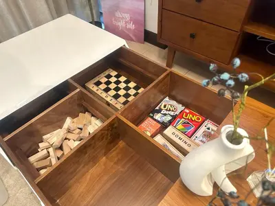 a wooden box filled with games and a table at Cozy 1BR at Greenbelt Hamilton Makati in Manila