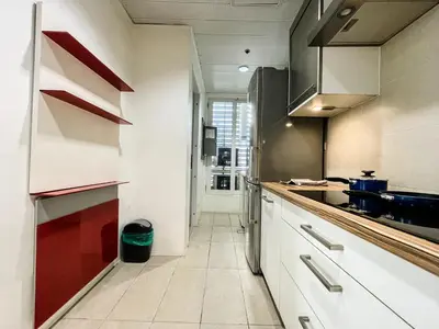 a kitchen with white cabinets and red accents at Full-Serviced Residential Apartment in Uptown, BGC in Manila