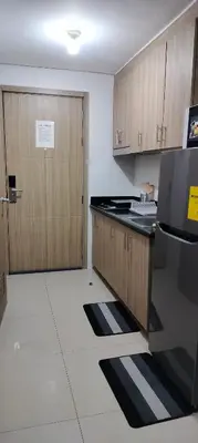a kitchen with wooden cabinets and a door with a counter at Carps Staycation in Manila