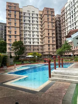 a large swimming pool with tall buildings in the background at Cozy studio unit 10mins from Airport 20mins from US Embassy across SM Sucat in Manila