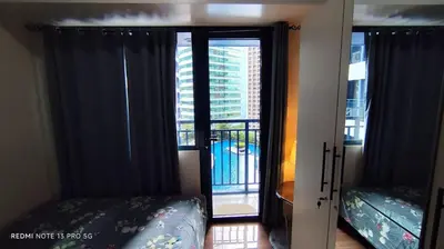 a bedroom with a door open to a balcony at Air Residence Tower B RM 445 Elegant and cosy Makati condoxd in Manila