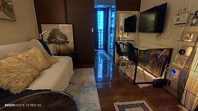 a living room with a white couch and a television at Air Residence Tower B RM 445 Elegant and cosy Makati condoxd in Manila