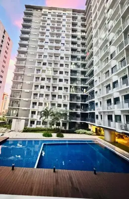 a swimming pool in front of a large building at Hearth of Ember 4 at Shore 3 Res in Manila