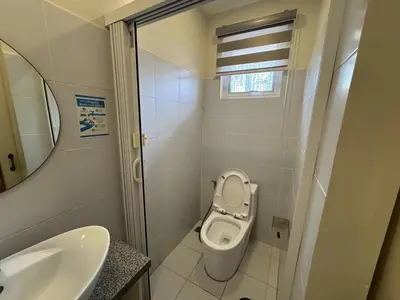 a small bathroom with a toilet and a sink at The Circuit Manor Hotel near Ayala Malls Circuit in Manila