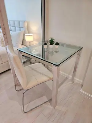 a glass table and a chair with plants on it at Rio Primea in Manila