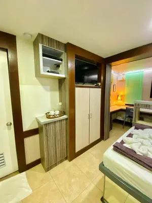 a room with a bed and a kitchen with a table at Casa Verde Hotel & Events Center in Imus