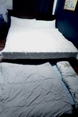 a bed with white sheets and pillows on it at Moody Space near NAIA TERMINALS in Manila
