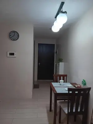 a dining room with a table and a clock on the wall at M&N Condotel in Manila