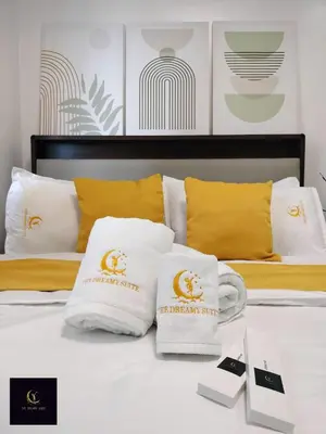 a bed with white pillows on it with yellow pillows at Newly opened near MOA & Airport with PS4 and karaoke in Manila