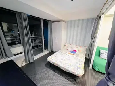 a bedroom with a bed with a book on it at Azure Urban Resort Staycation By Yana in Manila