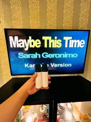 a person holding two white controllers in front of a tv at Azure Urban Resort Staycation By Yana in Manila
