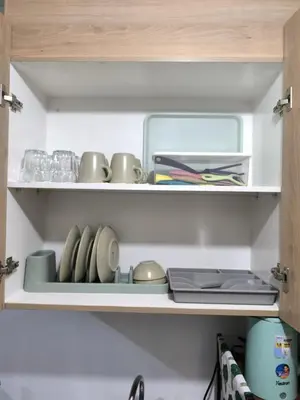 a cupboard with cups and other items on it at Shore 2 Residences - La Casa in Manila