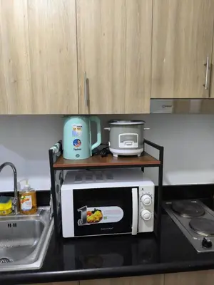 a kitchen counter with a microwave and a sink at Shore 2 Residences - La Casa in Manila