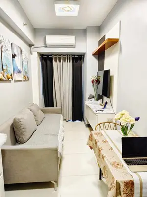 a small living room with a couch and a desk at ck staycation coast residence in Manila