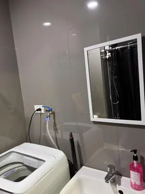 a bathroom with a toilet and a sink and a mirror at City chic in the heart of Makati #4609 in Manila