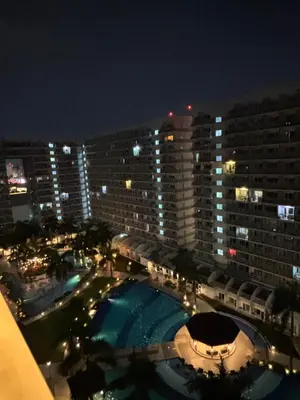 a view of a large building with a pool at night at Shell Residences - Rhoi in Manila