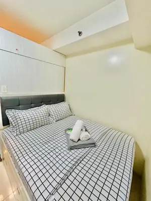 a bed with a tray with two towels on it at 1BR Affordable Room infront of Mall of Asia Near Airport in Manila