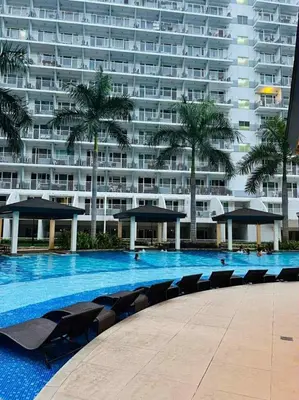 a large apartment building with a large swimming pool at SGG Suite Room Pool View - Shell Residences MOA Pasay Near NAIA in Manila