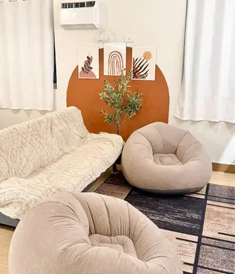 a living room with two chairs and a couch at Meraki Stays - ETANA - SMDC Hope Residences in Trece Martires