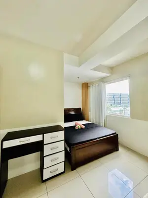 a bedroom with a bed with a desk and a window at SGG Manila 2Bedroom MOA View - Shell Residences MOA Near Airport in Manila