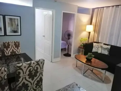 a living room with a couch and a table at Royale 2BR Condo unit with free WiFi in Imus