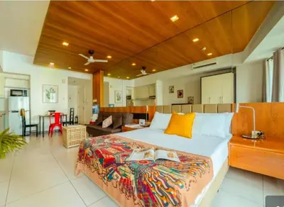a large bedroom with a large bed and a kitchen at Cozi Makati Executive Studio balcony in Manila
